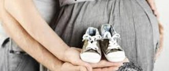 будущие родители держат детские ботиночки